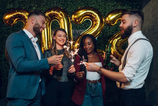 Deux hommes et deux femmes devant 2022 en ballons gonflables dorés